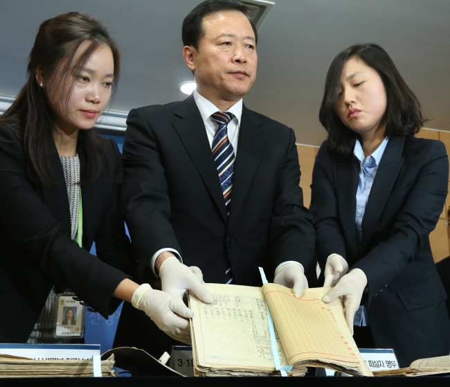 The National Archives President Park Kyung-kook and other staff hold a list of those who were killed during the March 1 independence movement in 1919 and in an alleged massacre by the Japanese during an earthquake in Kanto in 1923. (Yonhap News)