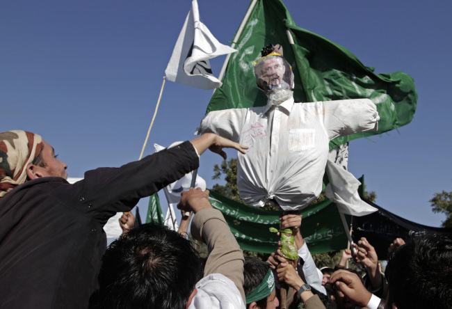 Afghan students shout antigovernment and U.S. slogans as they display an effigy of U.S. President Barack Obama with the word “donkey” scribbled across his forehead during a protest against the upcoming Loya Jirga, a traditional means of consultation, in Jalalabad, Afghanistan, Tuesday.   AP-Yonhap News