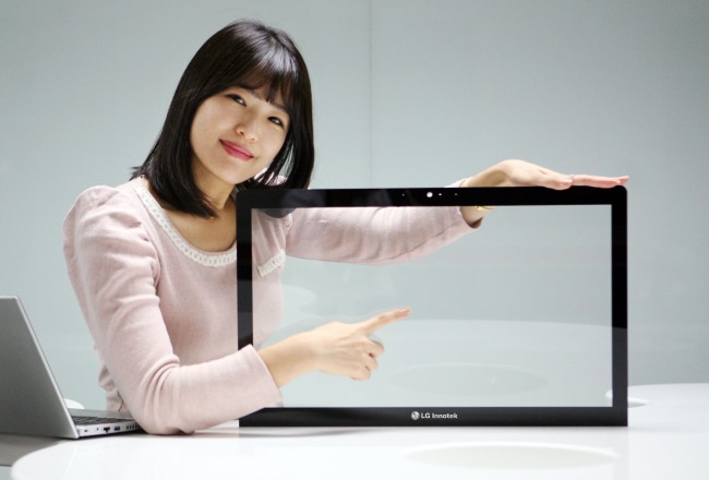 An LG Innotek employee poses with the Metal Mash, a touch screen panel that has been optimized for larger panels such as laptops and desktop monitors.   LG Innotek