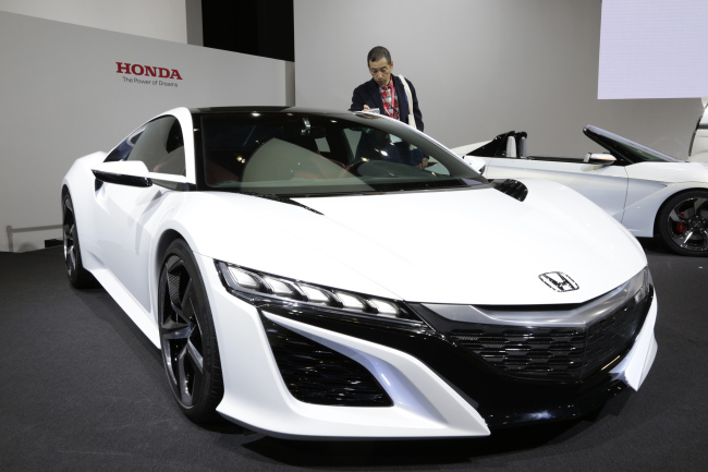 A visitor looks at a Honda NSX hybrid concept car at the media preview for the Tokyo Motor Show at Tokyo Big Sight convention hall on Wednesday.   AFP-Yonhap News