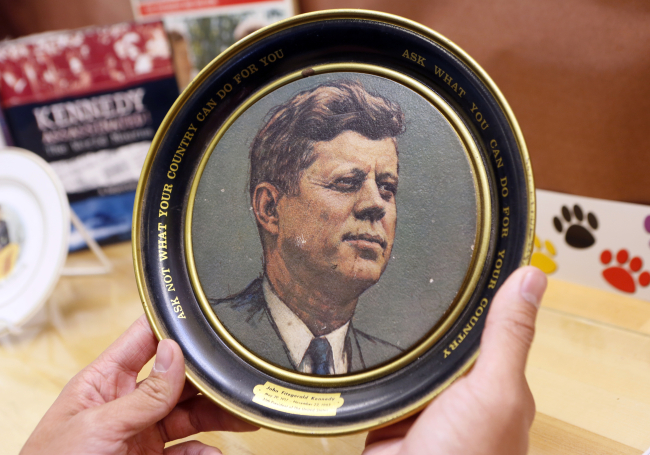 A vintage plate with U.S. President John F. Kennedy's inaugural address quote: "Ask not what your country can do for you, ask what you can do for your country," is displayed as part of the exhibit at the John F. Kennedy High School in Granada Hills, Calif., on Friday. (AP-Yonhap News)