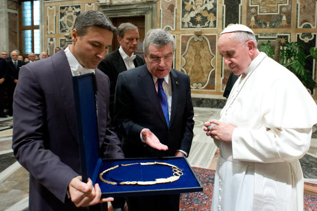 Pope Francis is presented a gift by Thomas Bach, president of the International Olympic Committee, in the Clementine hall at the Vatican on Saturday.   AP-Yonhap News