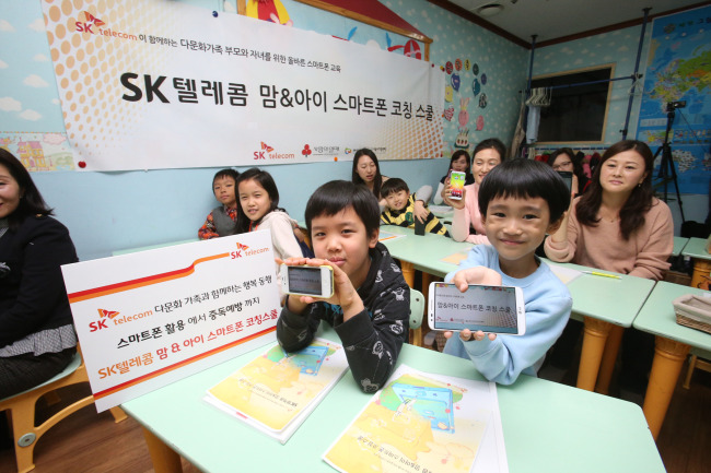 SK Telecom runs the “Mom & Kids Smartphone Coaching School” for multicultural families to teach them about the effective use of smartphones, at the Multicultural Family Support Center in Seoul on Saturday.   SK Telecom