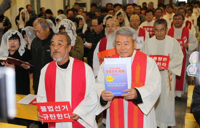 Priests from the Catholic Priests’ Association for Justice hold a Mass on Friday, where they demanded President Park Geun-hye to step down over the alleged irregularities in last year’s presidential election. (Yonhap News)