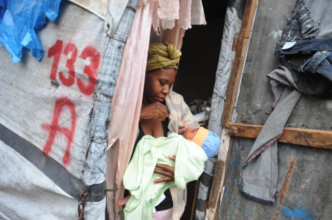 A woman holds her child at a camp for earthquake victims in Petionville, Haiti.   AFP