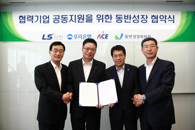Representatives from LSIS, its sub-contractor Buwon, Woori Bank and the government pose at a ceremony to sign an agreement for shared growth in August.   LSIS
