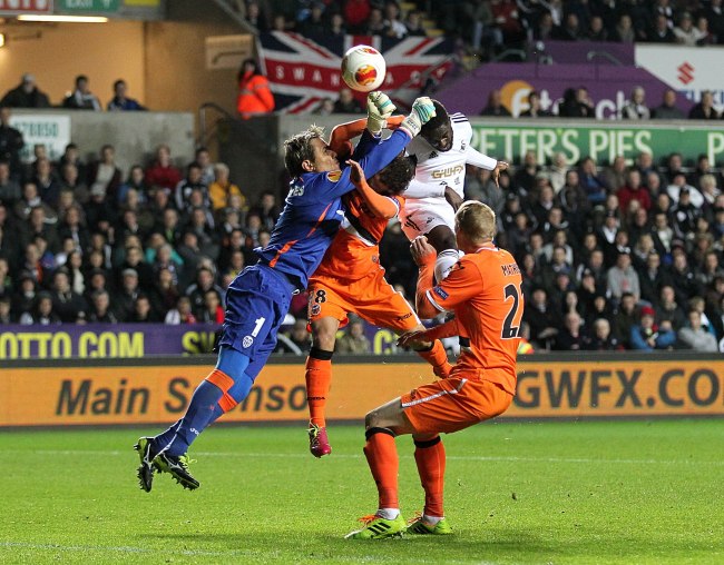 COLLISION: Valencia’s goalkeeper Carreira Diego Alves (left) makes a save against Swansea City during a Europa League Group A match on Thursday. Valencia won 1-0.   AP-Yonhap News