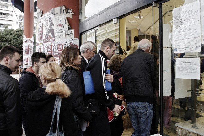 Job seekers pass through the doors of an OAED employment center soon after it opened in Thessaloniki, Greece.   Bloomberg