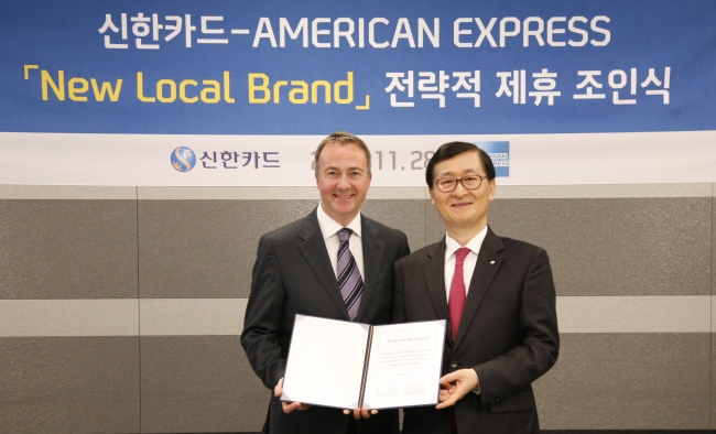 Shinhan Card CEO Wi Sung-ho (right) poses with Paul Abbott, head of American Express’ Global Network Partnerships, after the Korean card issuer signed an agreement to expand relations with the U.S. financial services company in Seoul.   Shinhan Card