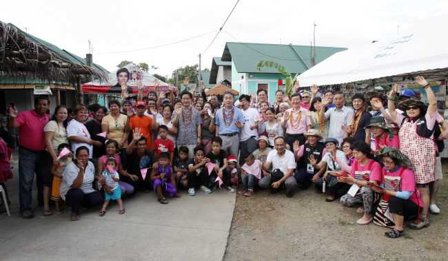 Gangneung city officials and Philippine residents pose in a ceremony to name their village “Pine City Gangneung” in Indang, Philippines, Saturday.   Gangneung City