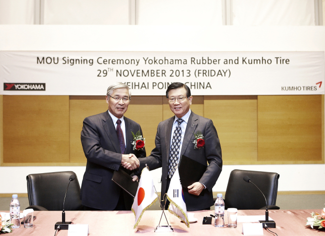 Kumho Asiana Group chairman Park Sam-koo (right) and Yokohama Rubber chairman Tadanobu Nagumo shake hands after signing a memorandum of understanding for strategic partnership at Weihai Point Resort in China on Friday.   Kumho Tires