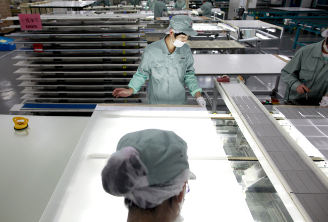 Employees assemble photovoltaic panels at Suntech Power Holdings Co.’s factory in Wuxi, Jiangsu province, China.   Bloomberg