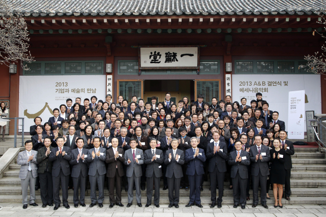 Culture Minister Yoo Jin-ryong (fifth from right, first row) and head of the Korean Business Council for the Arts Park Yong-hyun (sixth from left, first row) join hands with other members at the “Arts & Business” event in Seoul on Tuesday.   Korean Business Council for the Arts