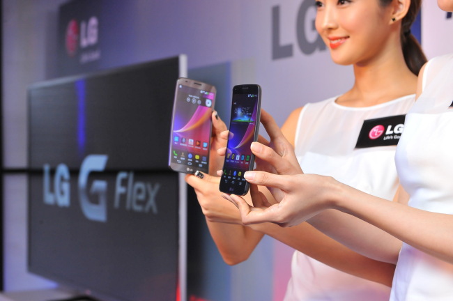 Models hold up LG Electronics’ curved smartphone, the G Flex, at a media briefing in Hong Kong.   LG Electronics