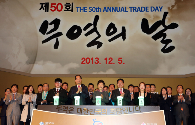 President Park Geun-hye (center) applauds at a ceremony to mark the 50th Trade Day in Coex, Seoul, Thursday.   Yonhap News