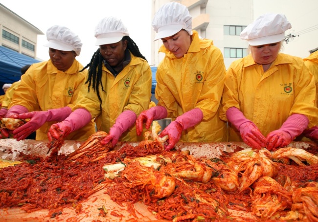 Wives of U.S. soldiers in South Korea participate in a charity event to make kimchi for low-income families on Thursday. (Yonhap News)