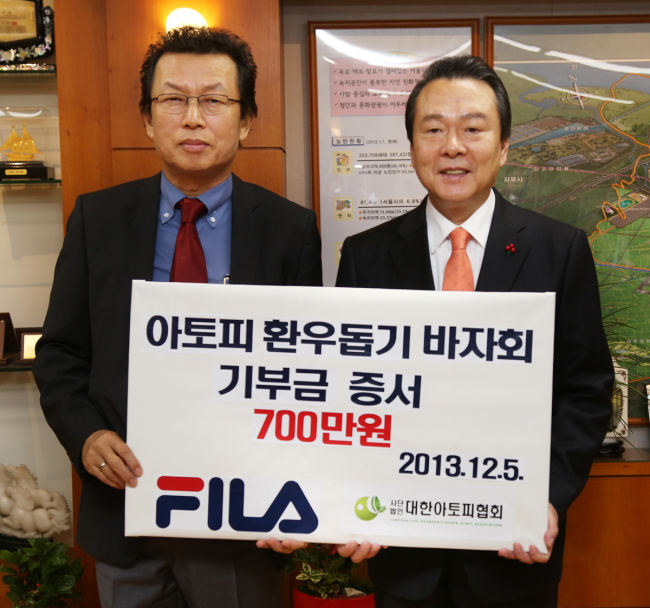 이기호 휠라코리아 사장(왼쪽)과 노현송 강서구청장이 5일 아토피 환우 돕기 자선바자회 기부금 전달식을 가진 뒤 기념촬영을 하고 있다.
사진=휠라코리아 제공