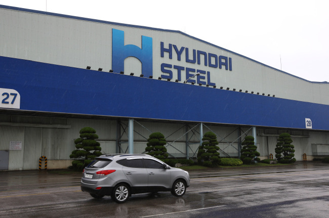 A car drives past the Hyundai Steel Co. plant in Dangjin, South Chungcheong Province.   Bloomberg