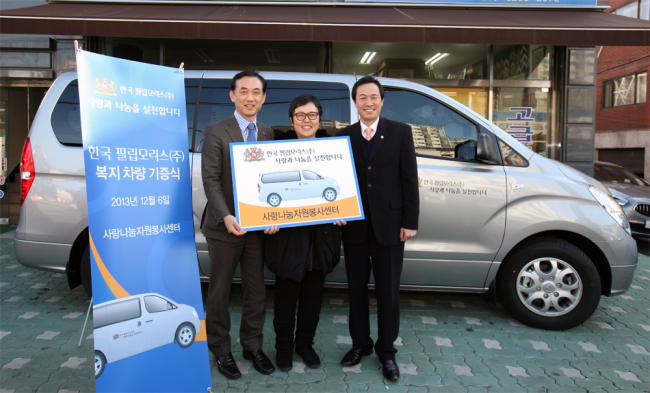 Philip Morris Korea executive director Kim Byung-chul (left) poses with Democratic Party lawmaker Woo Sang-ho (right) and Kim Hye-mi, representative from a voluntary service center in Seoul, after donating a vehicle to the charity organization on Friday.   Philip Morris
