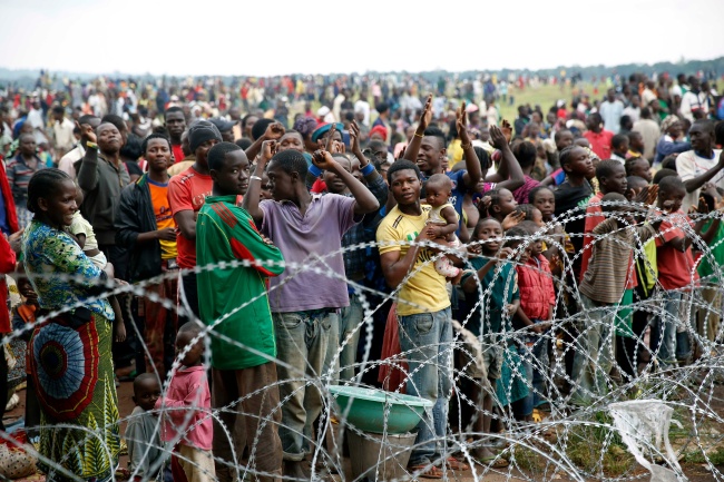 Internally displaced people who gathered at the airport in Bangui, Central African Republic, Friday, cheer at the sight of French military helicopters landing, a day after a gun battle between Seleka soldiers and Christian militias left more than 100 dead and scores wounded.   AP-Yonhap News