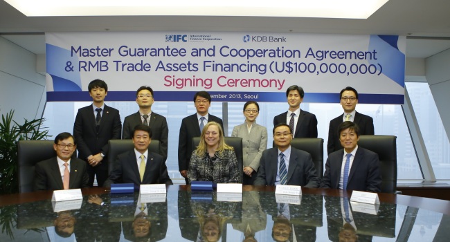 Korea Development Bank executive director Roh Yung-gi (second from left, front row), International Finance Corp. vice president Karin Finkelston (center, front row) and other participants pose at the signing ceremony of the master guarantee and cooperation agreement at the KDB headquarters in Yeouido, Seoul, Dec. 5.   KDB