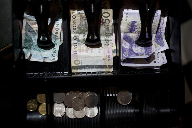 Mixed denomination Swedish kronor notes and coins sit in a cashier’s till inside a currency exchange in Malmo, Sweden.   Bloomberg