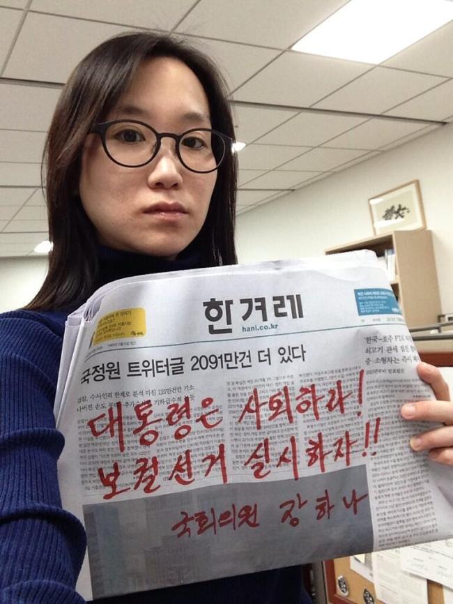 장하나(국회의원/민주당국회의원)
Rep. Jang Ha-na holds up a newspaper on which she has written “President resign! Let’s hold a by-election” in her office at the National Assembly in a photo she posted online Sunday.   Yonhap News