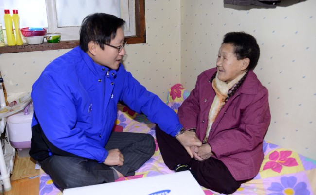 Samsung C&T president and CEO Kim Shin delivers gifts and household supplies to 80-year-old Kim Ok-ji as part of the company’s community service for residents of tiny flophouses in Seoul on Wednesday.   Park Hae-mook/The Korea Herald