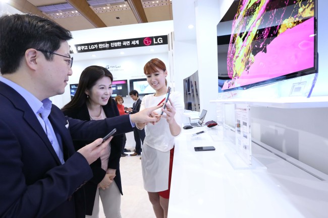 창조경제박람회 LG 전시관에서 관람객들이 커브드 스마트폰 ‘LG G 플렉스’를 살펴보고 있다. [사진제공=LG]