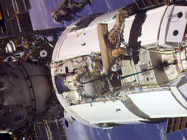 Two Russian flight engineers perform maintenance on the International Space Station.   AP-Yonhap News
