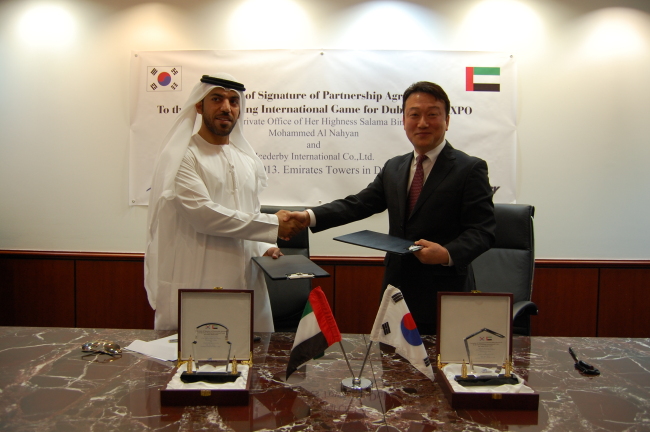 Icederby International president and CEO Hyun Do-jung (right) shakes hands with Saif Saeed Al Mazrouie, business office director of the Private Office of UAE Sheikha Sallama Bint Tahnoun Bin Mohammed Al Nahyan after signing an agreement on the joint launching of the 2020 Dubai Expo celebration event in Dubai on Thursday. (Icederby International)