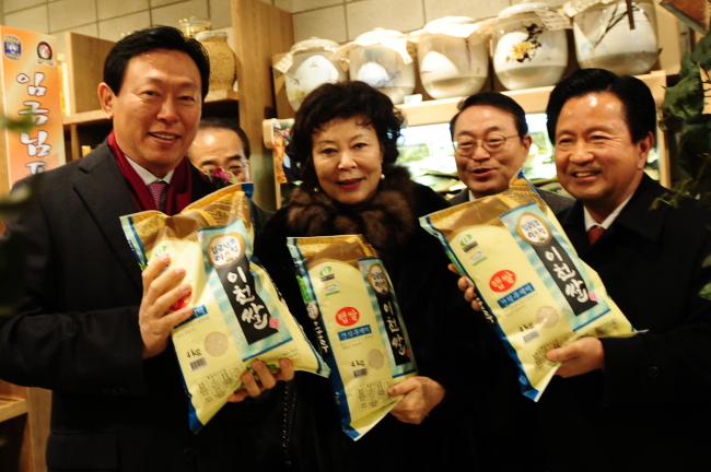 Lotte Group chairman Shin Dong-bin (left) and other participants hold packs of rice harvested in Icheon, Gyeonggi Province, during a ceremony to open Asia’s largest premium outlet in the city on Friday. From left: Shin, Lotte Foundation chairwoman Shin Young-ja, Lotte Department Store CEO Shin Heon and ruling party lawmaker Yoo Seung-woo.   Lotte Department Store