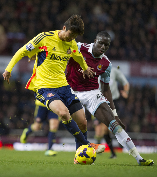 Sunderland’s Ki Sung-yueng (left) and West Ham’s Mohamed Diame battle for the ball on Saturday.   AP-Yonhap News