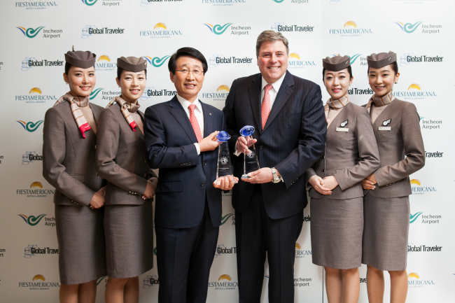 Han Tae-keun, executive vice president of corporate support at Asiana Airlines (third from left) poses with Francis Gallagher (third from right), CEO and publisher of Global Traveler, and Asiana flight attendants at Peninsula Beverly Hills Hotel in Los Angeles on Wednesday. Asiana Airlines received the Best Airline Onboard Service and Best Airline for Flight Attendants awards from Global Traveler magazine for the 10th straight year.   Asiana Airlines