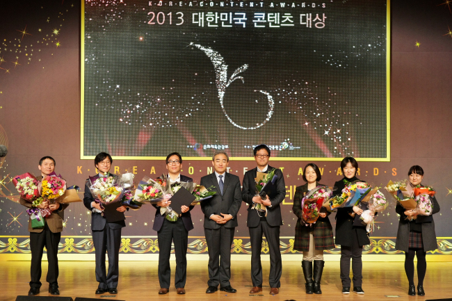 Culture Minister Yoo Jin-ryong (fourth from left), poses with winners of the Korea Content Awards 2013 including TV writer Lee Woo-jung (second from right) at Coex in southern Seoul on Friday.   Korea Creative Content Agency