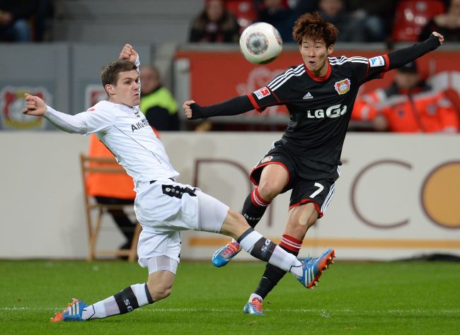 Leverkusen’s South Korean striker Son Heung-min (right) and Frankfurt’s Swiss midfielder Pirmin Schwegler vie for the ball on Sunday.    AFP-Yonhap News