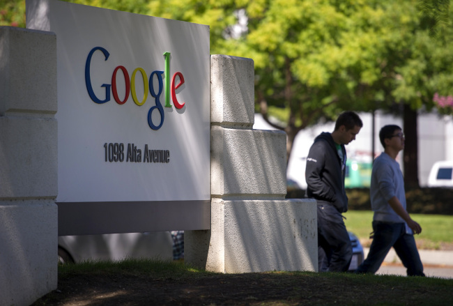 Pedestrians walk past Google Inc.’s headquarters in Mountain View, California.   Bloomberg