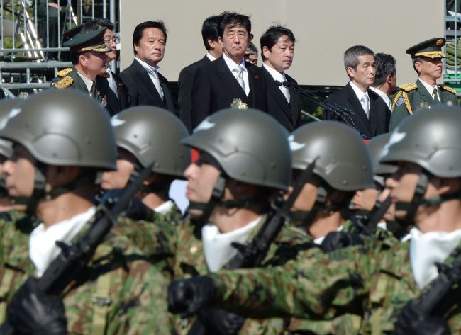 This picture taken on Oct. 27 shows Japanese Prime Minister Shinzo Abe (top center) inspecting troops of Japan’s Self-Defense Force during a military review at the Ground Self-Defense Force’s Asaka training ground in suburban Tokyo.   AFP-Yonhap News