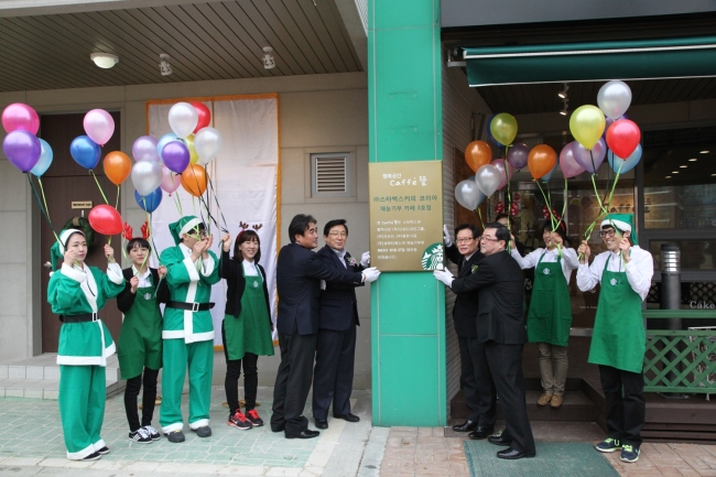 Starbucks Korea CEO Lee Suk-koo (sixth from left) poses with Daejeon Hyekwang School headmaster Song Suk-woong (seventh from left) and Daejeon Vocational Competency Development Center director Kwon Ki-sung (eighth from left) at a signboard-hanging ceremony for the renewal of the school’s cafe “Ddeul,” in Daejeon on Tuesday. The cafe is Starbucks Korea’s third location for its talent donation program, which offers barista training for disabled students.   Starbucks Korea