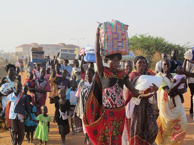 In this handout image from the United Nations Mission in South Sudan, taken on Tuesday, civilians arrive at UNMISS compound adjacent to Juba International Airport to take refuge.   AP-Yonhap News