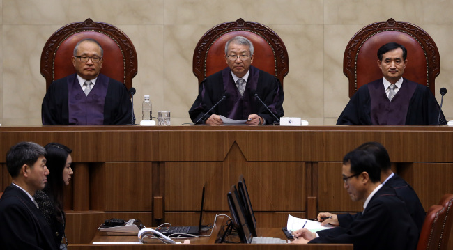 Members of the Supreme Court, including Chief Justice Yang Seung-tae (center), are about to announce a landmark ruling that decided bonuses, if paid out regularly, constitute part of “ordinary wages.” (Yonhap News)