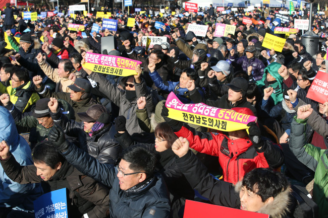 Doctors protest the government’s plan to allow telemedicine and for-profit hospital subsidiaries at a rally organized by the Korea Medical Association in Seoul on Sunday.   Yonhap News