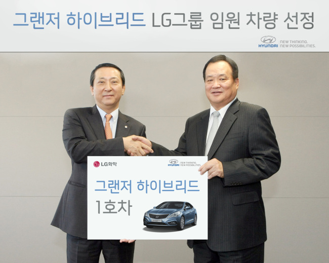 김충호(왼쪽) 현대자동차 사장과 권영수 LG화학 사장이 18일 ‘그랜저 하이브리드’ 1호차 전달식을 갖고 있다.   [사진제공=현대자동차]