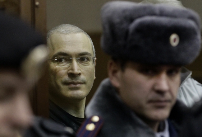 Mikhail Khodorkovsky (left) looks from behind glass at a court room in Moscow on Dec. 30, 2010.   AP-Yonhap News
