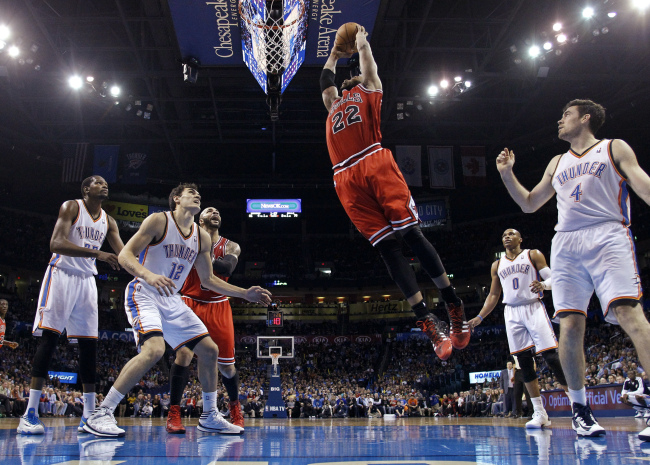 Chicago Bulls forward Taj Gibson (22) goes up for a dunk in front of Oklahoma City Thunder forward Kevin Durant (35), center Steven Adams (12), guard Russell Westbrook (0) and forward Nick Collison (4) during an NBA basketball game in Oklahoma City on Thursday.   AP-Yonhap News