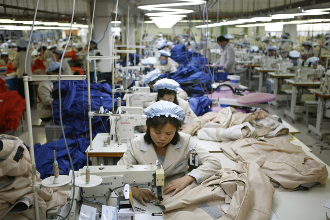 North Korean workers assemble jackets at a factory of a South Korean-owned company in the jointly run industrial complex in Gaeseong, North Korea, Thursday.   AP-Yonhap News