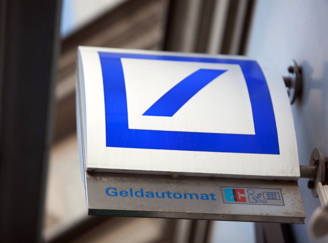 A Deutsche Bank AG logo sits on a sign for an automated teller machine in Berlin.   Bloomberg