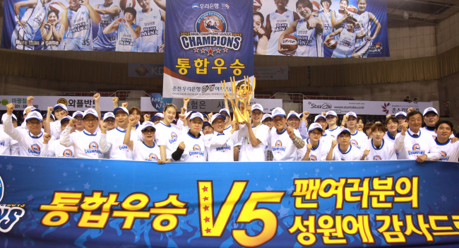 이순우(가운데) 우리금융그룹 회장 겸 우리은행장이 2012~2013년 시즌 여자프로농구 통합 우승을 차지한 우리은행 한새농구단과 함께 우승 트로피를 들어보이면서 기쁨을 만끽하고 있다.  [사진제공=우리은행]