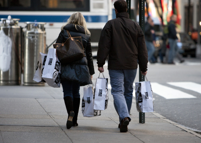 Shoppers carry bags outside of a Saks Fifth Avenue department store in New York.   Bloomberg