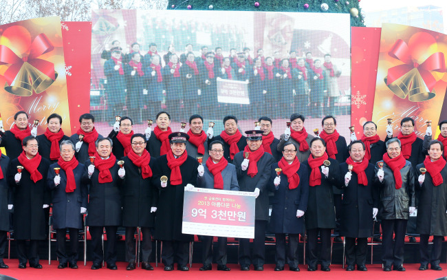Choi Soo-hyun (sixth from left, front row), governor of the Financial Supervisory Service, and representatives from 37 financial institutions ring bells after delivering 930 million won in donations to Park Jong-deok (fifth from left, front row), commander of the Salvation Army Korea Territory, in Seoul on Tuesday.   Yonhap News